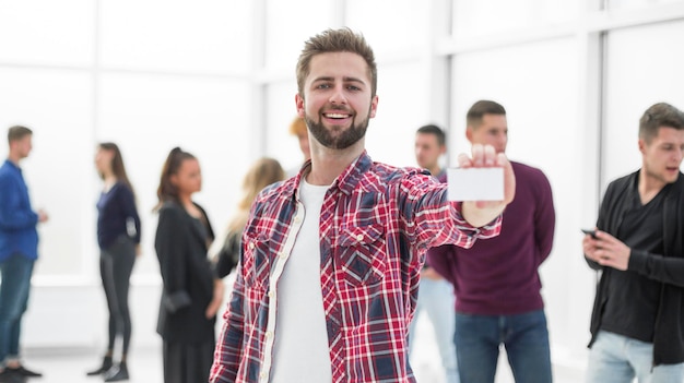 Diseñador joven sonriente que muestra su tarjeta de visita