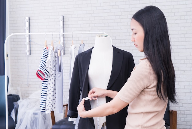 El diseñador de moda japonés del paño está midiendo la chaqueta