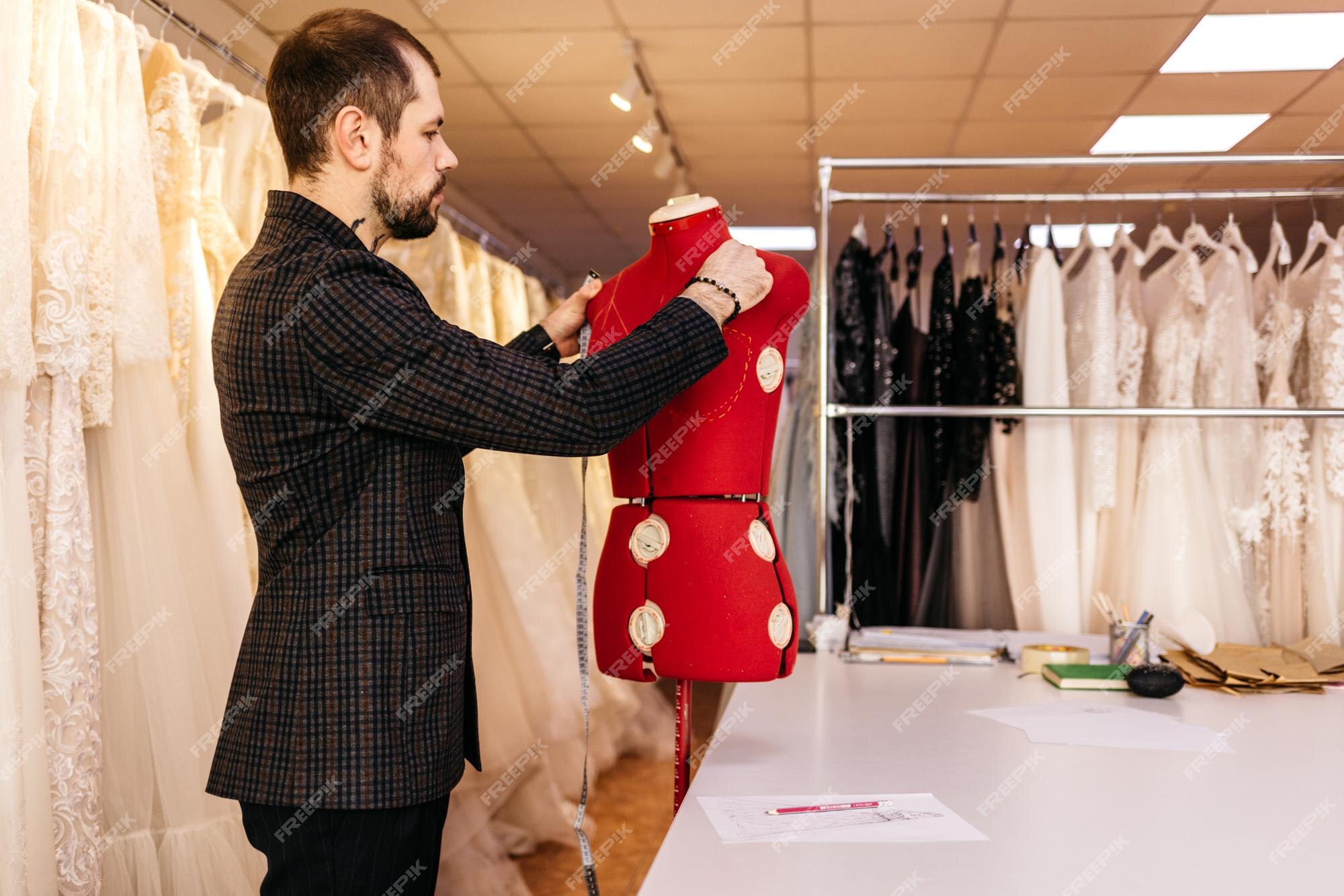 Un diseñador de moda masculino serio dibujando bocetos de una nueva  colección de ropa en un estudio de diseño étnico sastre creando una línea  trabajando con pincel o lápiz en un escritorio personal desarrollando un  patrón de bordado | Foto Premium