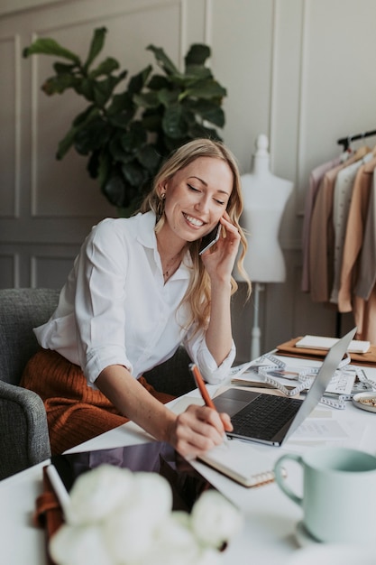 Diseñador de moda en el teléfono en el estudio.