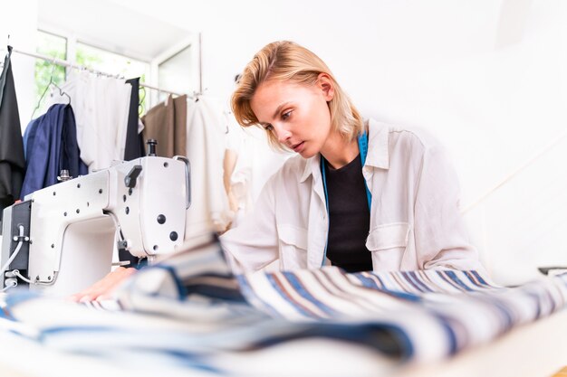 Diseñador de moda trabajando en un taller de puesta en marcha de ropa - Sastre de ropa trabajando en una nueva colección