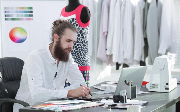 El diseñador de moda usa una tableta gráfica para crear bocetos de ropa
