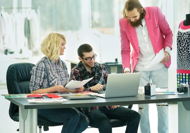 El diseñador moderno y su equipo están trabajando en nuevos modelos en el estudio creativo de indumentaria.