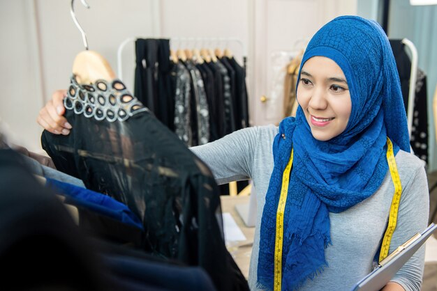 Diseñador de mujer musulmana asiática en su sastrería