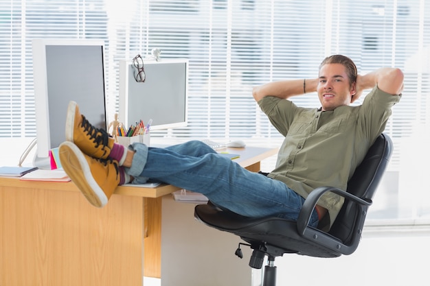 Foto diseñador que se relaja con el pie en el escritorio