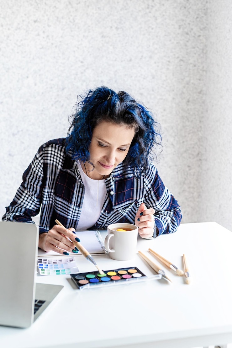 Foto diseñador que trabaja con paletas de colores y portátil en su estudio de arte