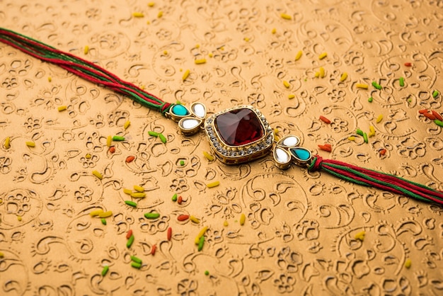 Diseñador Rakhi / Raakhi o pulsera para el festival indio Raksha Bandhan, aislado sobre una superficie decorativa