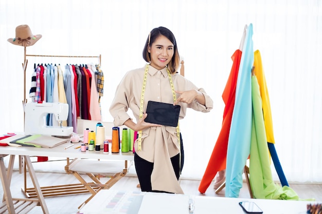 Foto diseñador de ropa apuntando a la pantalla de la tableta