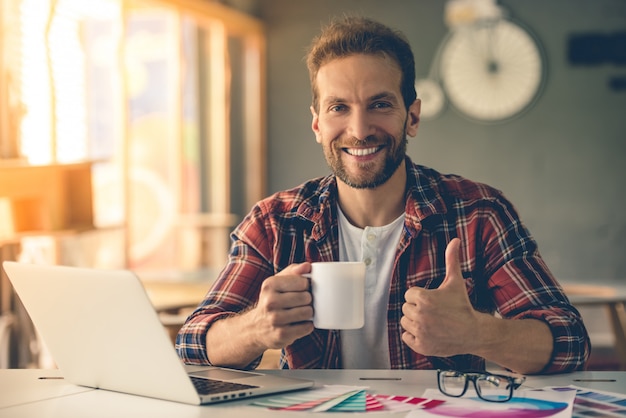 diseñador en ropa casual está sosteniendo una taza