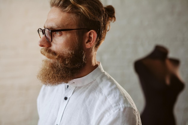 diseñador de ropa joven moderno en el proceso de trabajo, diseñador de ropa con pelo largo y barba