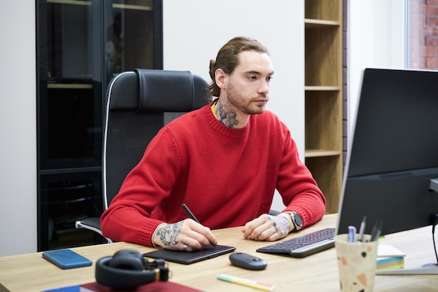 Diseñador trabajando en tableta gráfica en la oficina