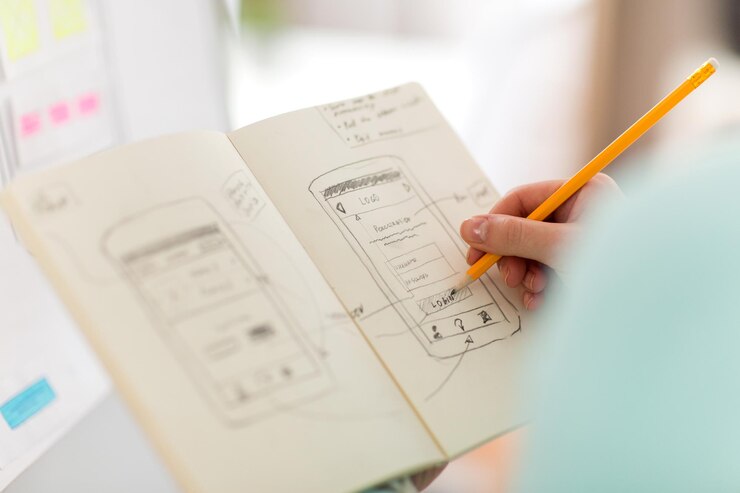 Foto diseñador de ui con boceto de interfaz de usuario en el cuaderno