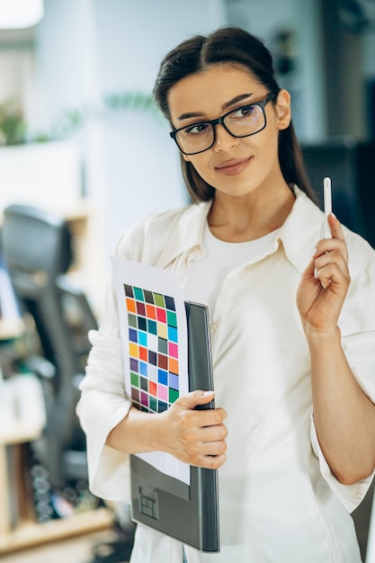 Diseñadora digital femenina mirando muestras en una oficina