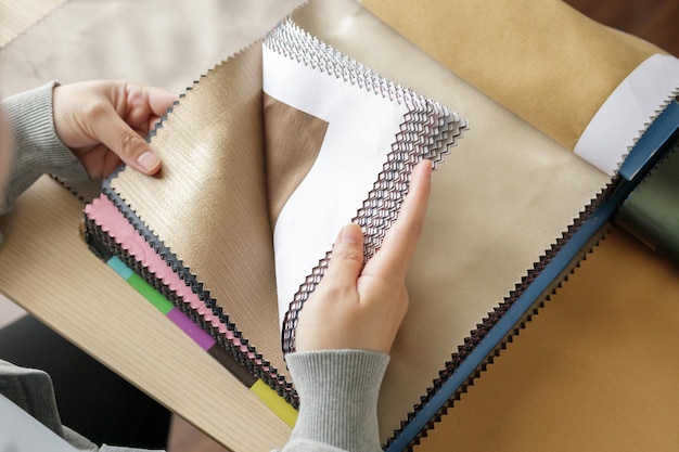 diseñadora femenina con muestras de color de tela eligiendo textiles para cortinas