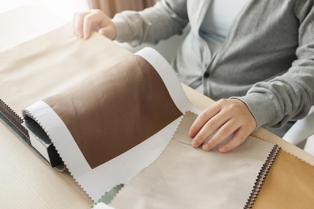 diseñadora femenina con muestras de color de tela eligiendo textiles para cortinas