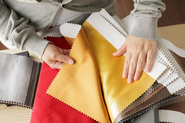 diseñadora femenina con muestras de color de tela eligiendo textiles para cortinas