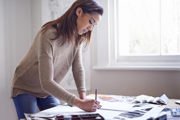 Foto diseñadora gráfica mujer de negocios y dibujo en papel en el escritorio con regla para el proyecto en la puesta en marcha creativo serio y artista en la mesa con planificación de bocetos o trabajo profesional en el arte con lápiz