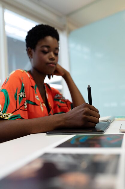 Foto diseñadora gráfica trabajando en una tableta gráfica en su escritorio