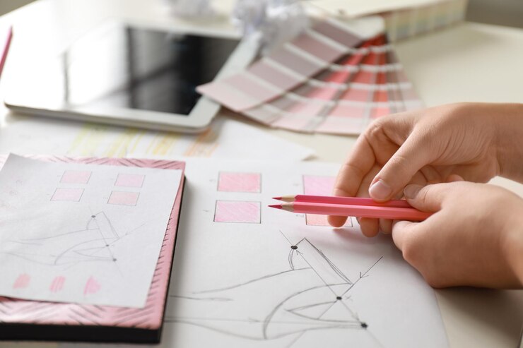 Foto diseñadora de moda femenina que trabaja en el primer plano de la mesa blanca