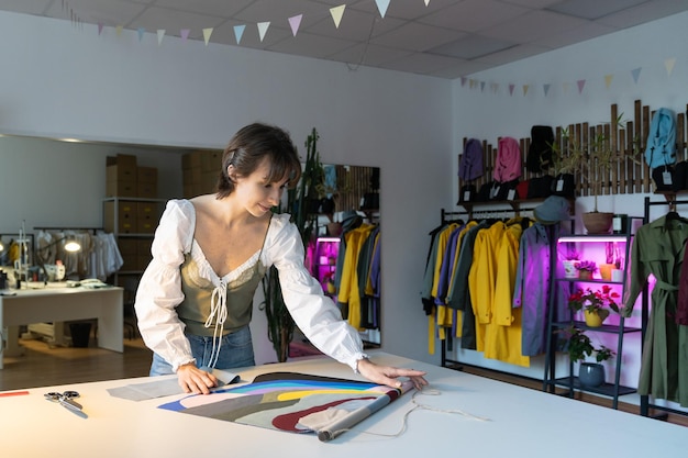 La diseñadora de moda trabaja tarde en el taller eligiendo muestras textiles para la nueva colección de ropa