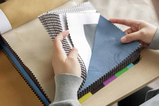 Diseñadora con muestras de color de tela eligiendo textiles para cortinas