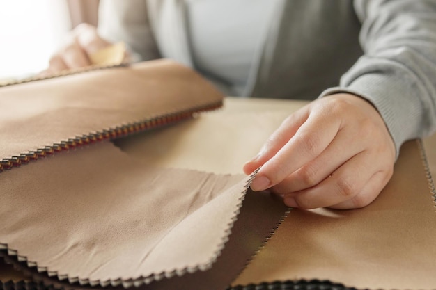 Diseñadora con muestras de color de tela eligiendo textiles para cortinas