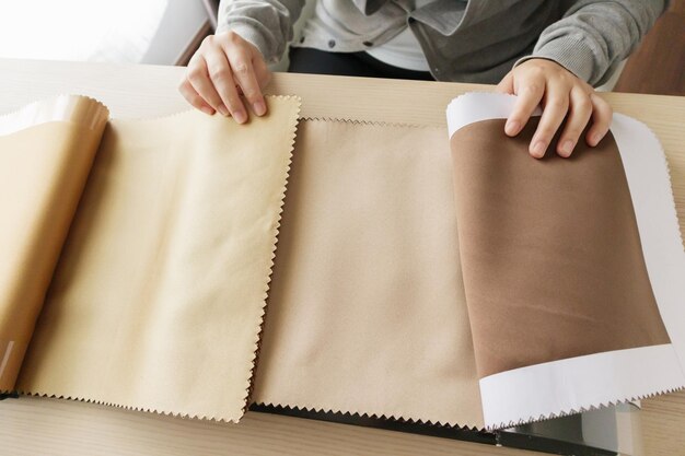 Diseñadora con muestras de color de tela eligiendo textiles para cortinas