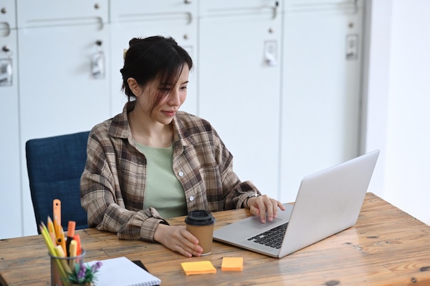 Diseñadora que trabaja con una computadora portátil en la oficina