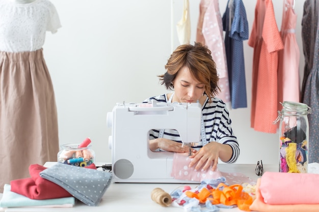 Diseñadora de ropa, costurera, concepto de personas - costurera de mujer trabajando en su estudio