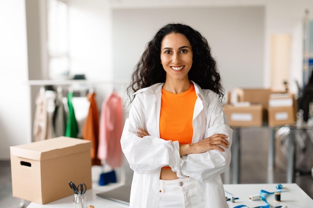 Diseñadora de ropa profesional mujer de pie en el estudio de diseño de moda moderna