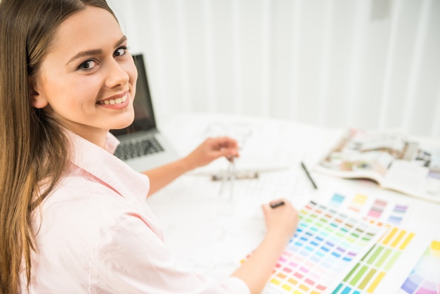 Diseñadora trabajando en su oficina doméstica con muestras de color.