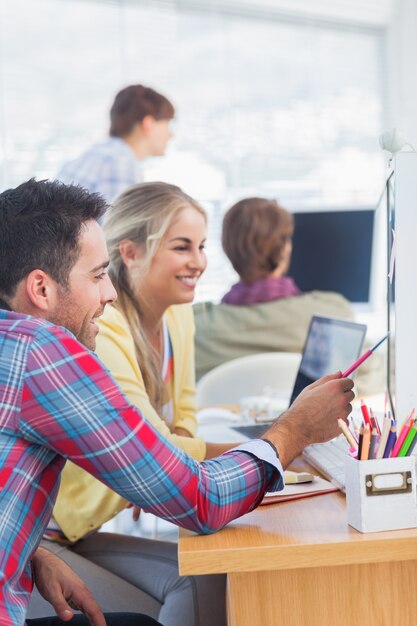 Diseñadores alegres trabajando juntos en su oficina