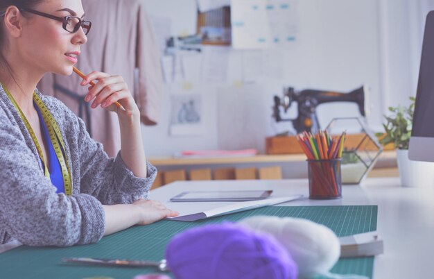 Diseñadores de moda trabajando en estudio sentado en el escritorio