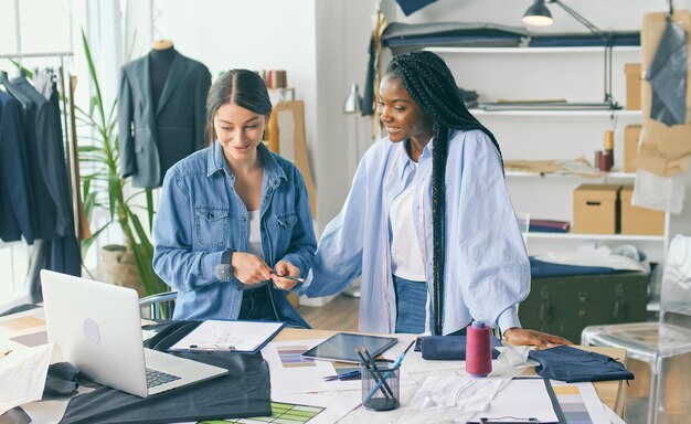 Foto diseñadores de raza mixta crean nuevas colecciones de ropa trabajan con bocetos