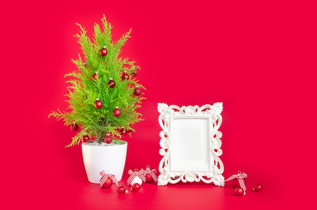 Diseño de Año Nuevo sobre un fondo rojo, un árbol de Navidad y un marco blanco para el texto