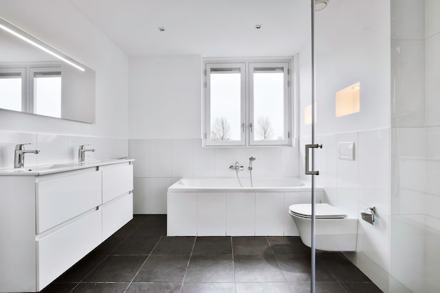 Diseño de baño moderno con suelo de baldosas negras y paredes y ventanas blancas