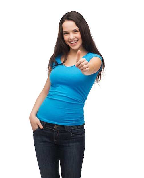 diseño de camisetas y concepto de gente feliz - niña sonriente en camiseta azul en blanco mostrando los pulgares para arriba