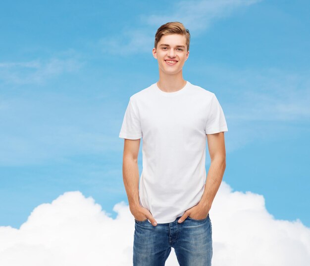 diseño de camisetas, publicidad, sueño y concepto de personas - joven sonriente con una camiseta blanca en blanco sobre fondo de cielo azul