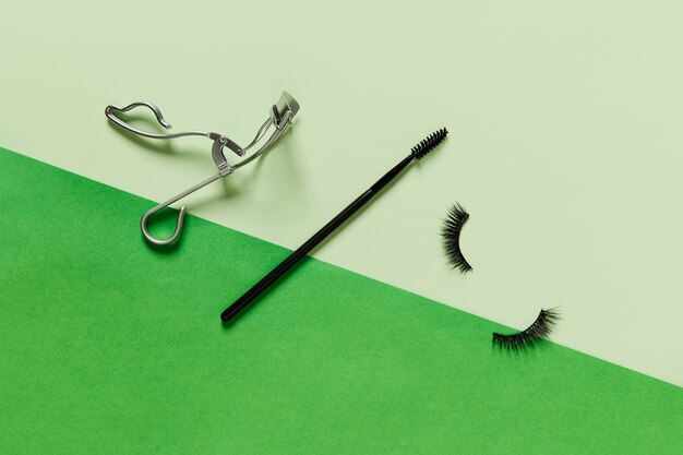 Foto diseño creativo con accesorios de maquillaje sobre fondo verde
