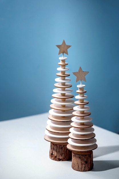 Diseño creativo de tarjeta de felicitación de año nuevo de Navidad con decoración navideña moderna abetos de madera y elementos creativos de acuarela sobre azul