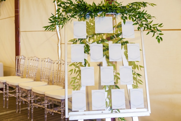 Diseño y decoración de la decoración de la celebración de la boda con rosas blancas, hojas verdes, velas y ramos de flores.