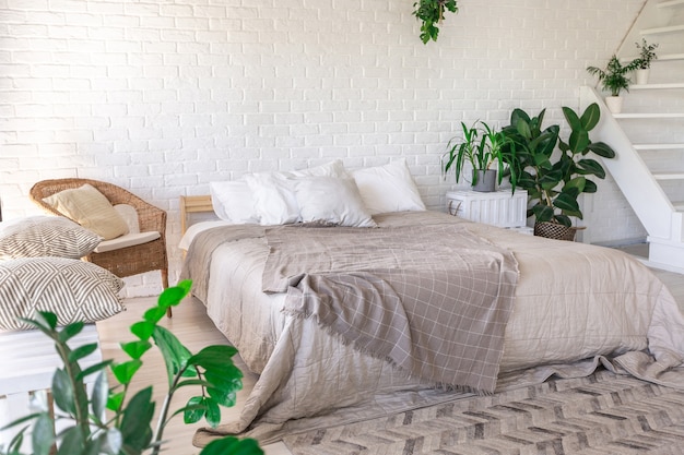 Diseño de dormitorio de lujo en una cabaña rústica de estilo minimalista. paredes blancas, ventanas panorámicas, elementos de decoración de madera en el techo, columpios de cuerda en medio de una habitación espaciosa.