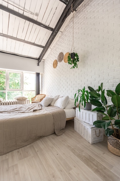 Diseño de dormitorio de lujo en una cabaña rústica de estilo minimalista. paredes blancas, ventanas panorámicas, elementos de decoración de madera en el techo, columpios de cuerda en medio de una habitación espaciosa.