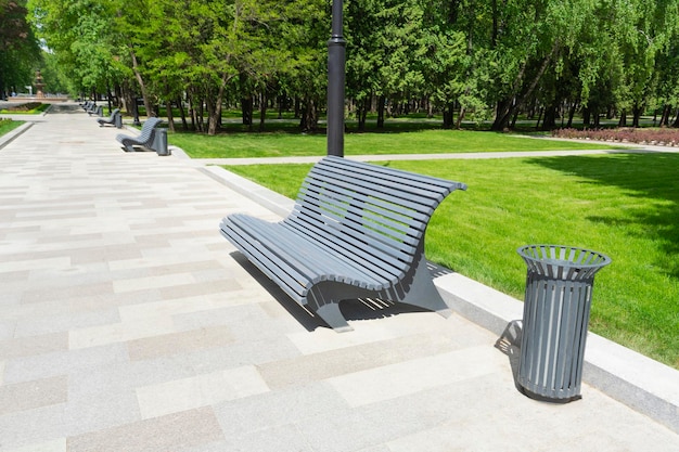 Diseño del entorno urbano del parque de verano Un banco y un bote de basura.