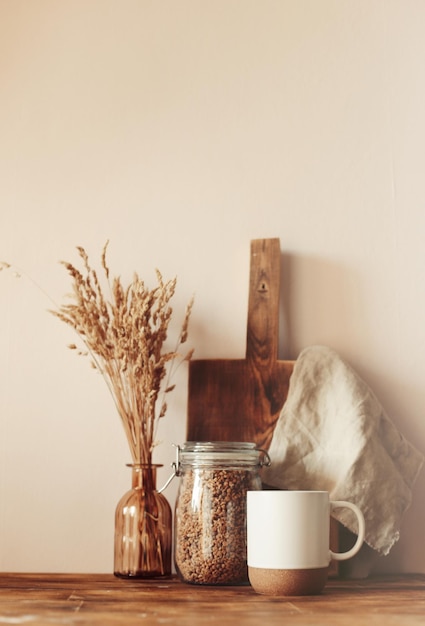 Diseño de escena de otoño. una taza de café, tablas de cortar de madera y flores secas a la luz del sol.