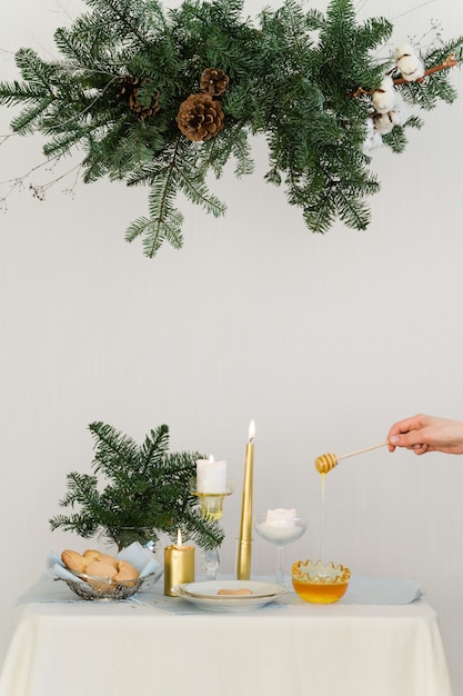 Diseño estético para navidad con guirnalda colgante de pino nobilis, velas y adornos de mesa. Foto de alta calidad