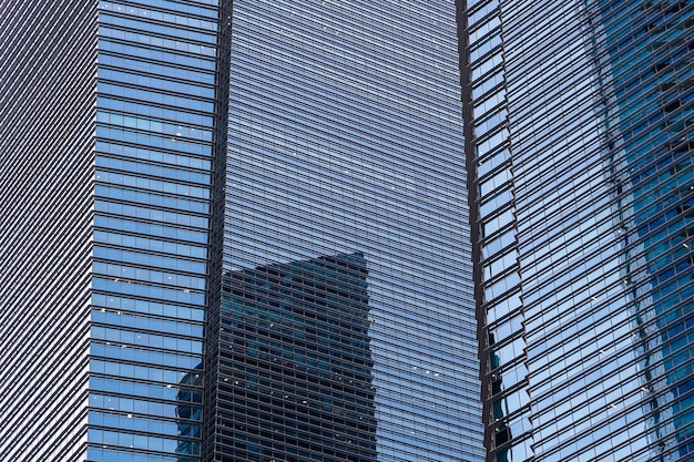 Diseño de fachada de arquitectura de cristal azul en ciudad urbana, centro de la ciudad de Singapur en el distrito financiero. Ventanas de edificios de oficinas. Detalle y patrón de edificio moderno, realizado en vidrio y acero.