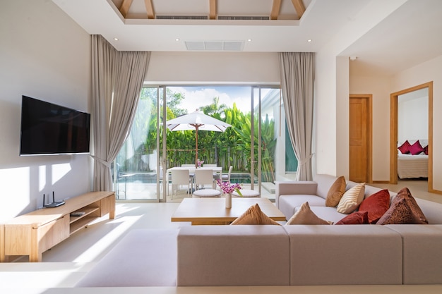 Diseño interior y exterior de sala de estar con vista a la piscina en villa de lujo con piscina