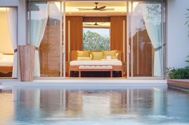 Diseño interior de lujo en el dormitorio de la villa con piscina y cama extragrande