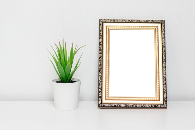 Diseño interior minimalista con marco de fotos y una planta en maceta blanca en un escritorio